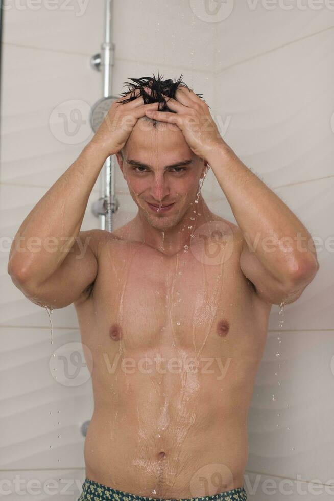 man taking shower in bath photo