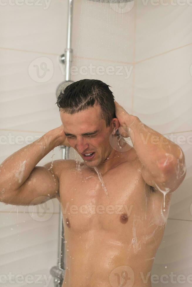 man taking shower in bath photo