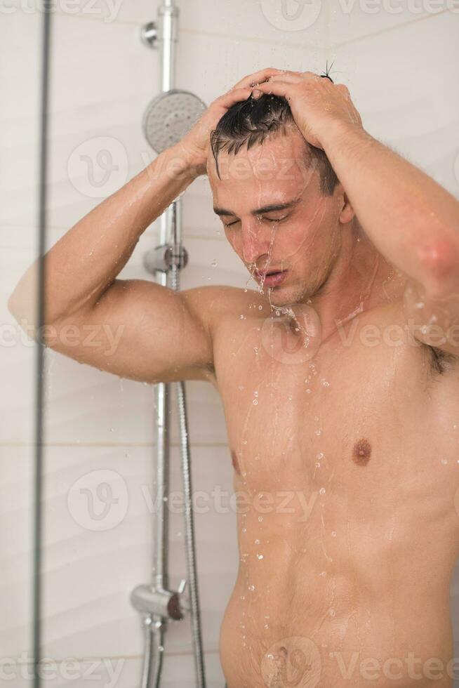 man taking shower in bath photo