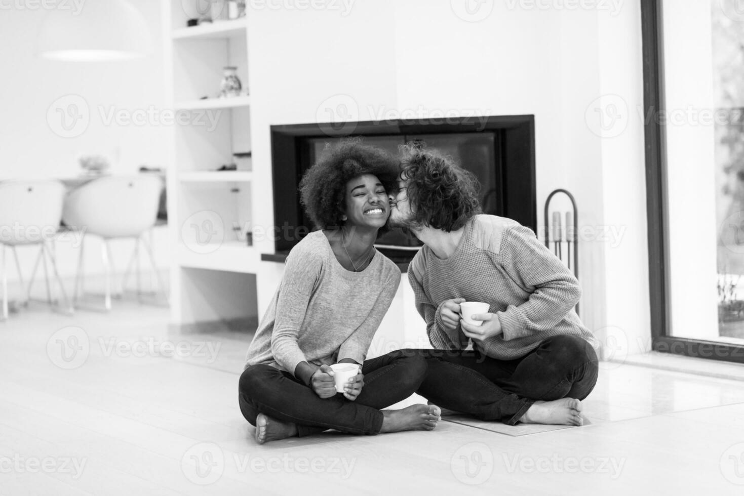 multiethnic couple  in front of fireplace photo