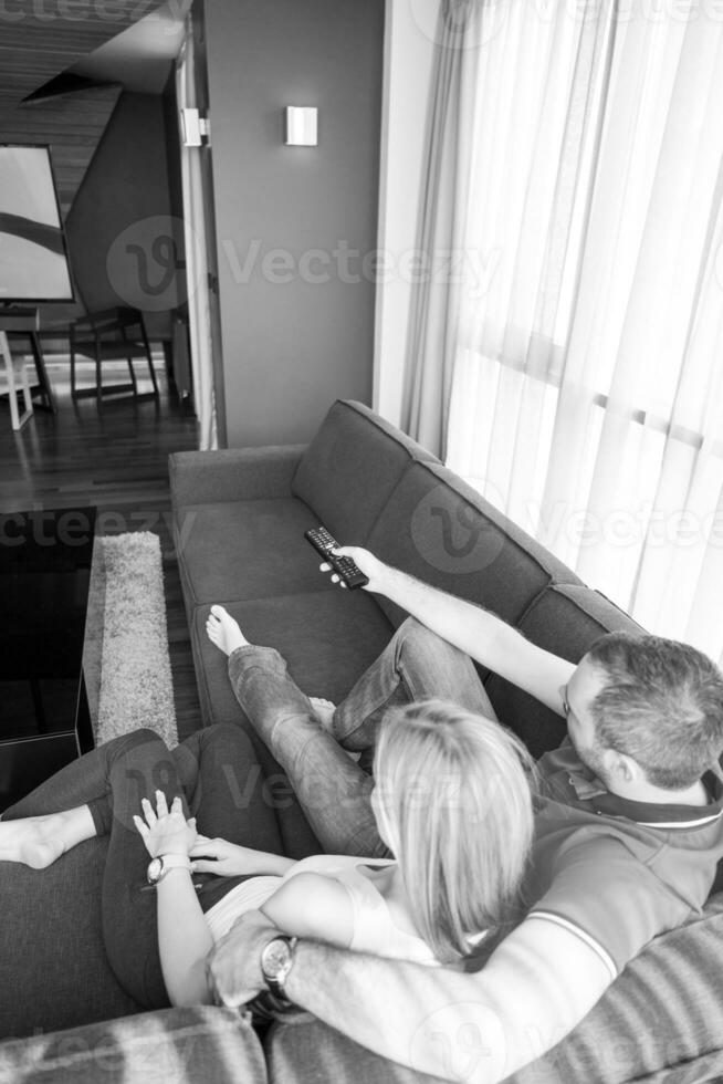 Young couple on the sofa watching television photo