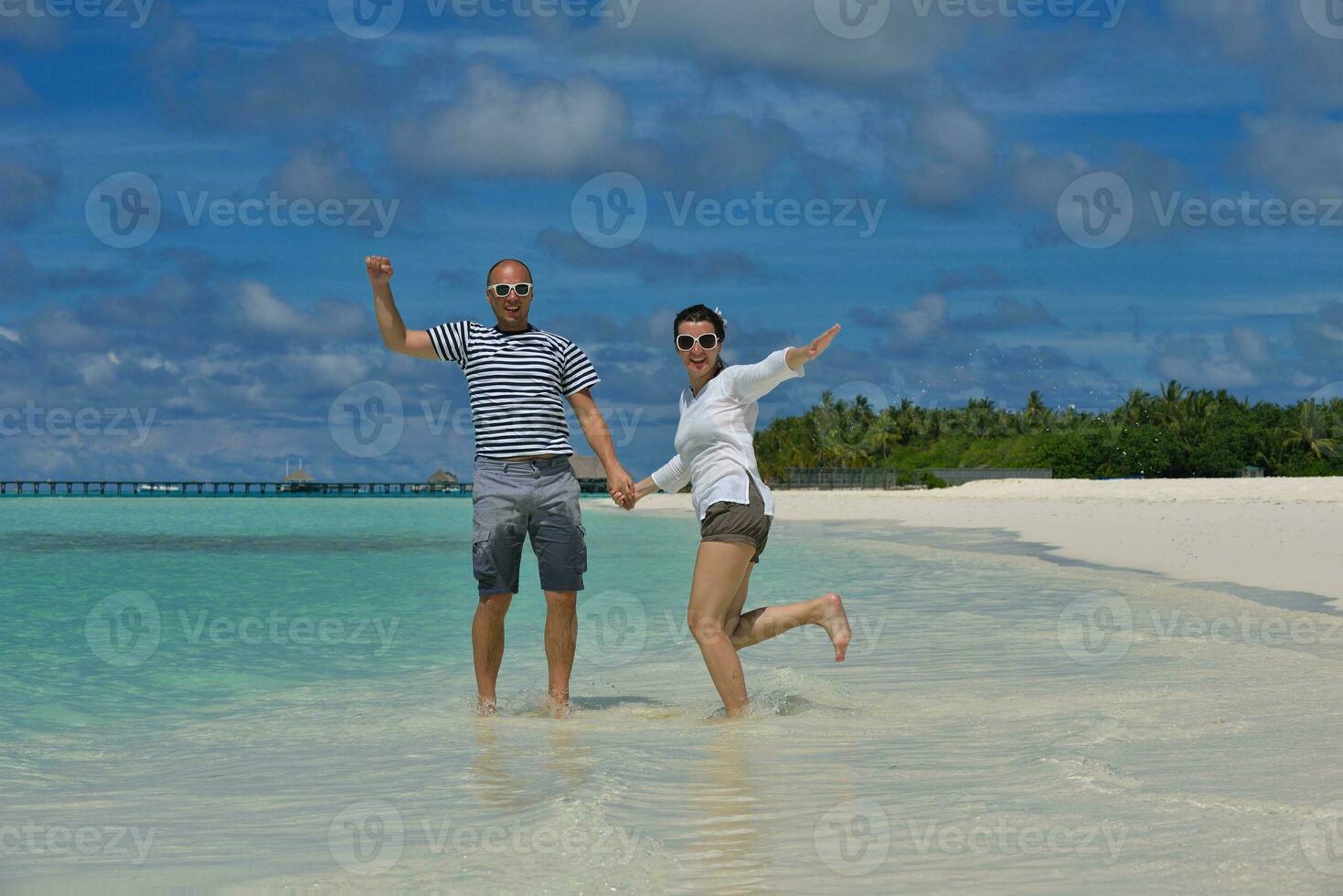happy young couple have fun on beach photo