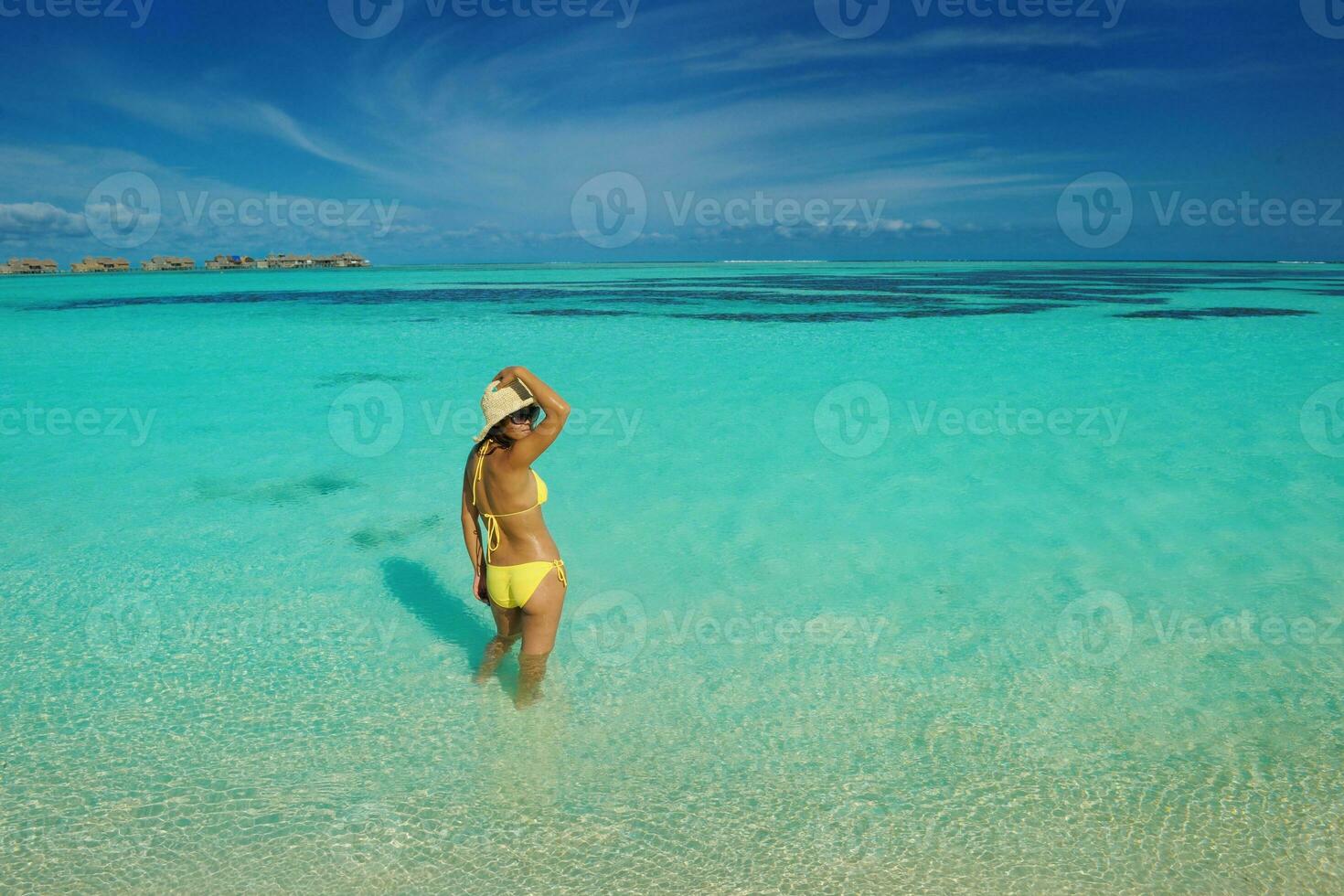 asian woman resting on sand at beach photo