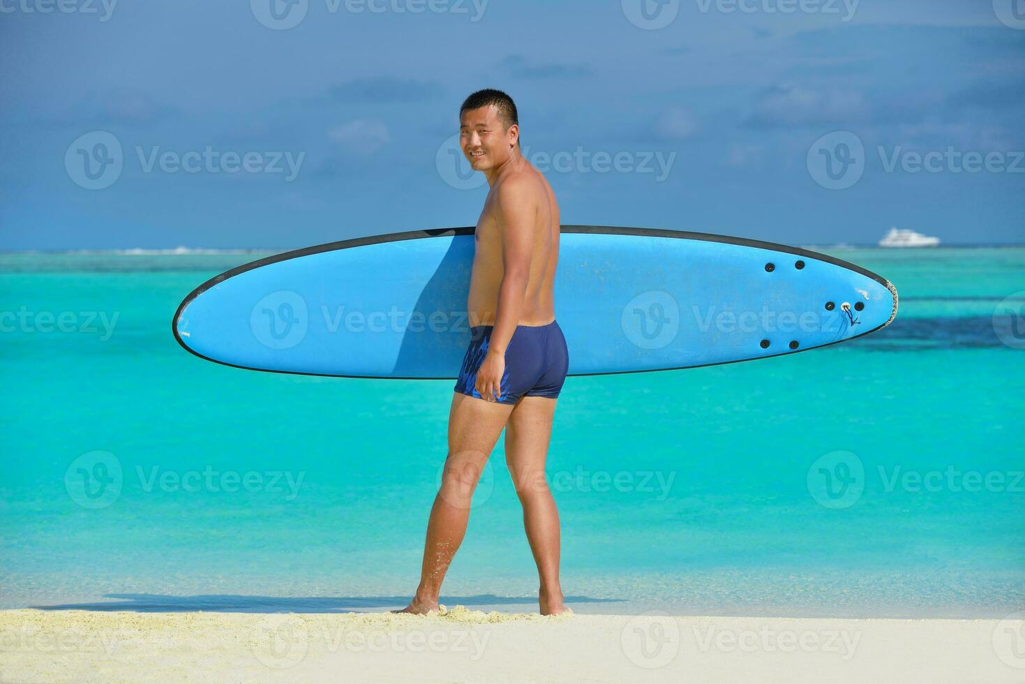 Man with surf board on beach photo