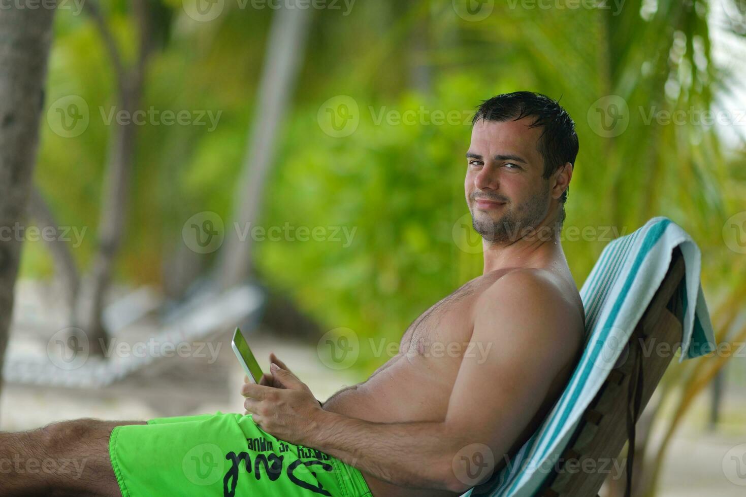 man ralaxing and use tablet at beach photo