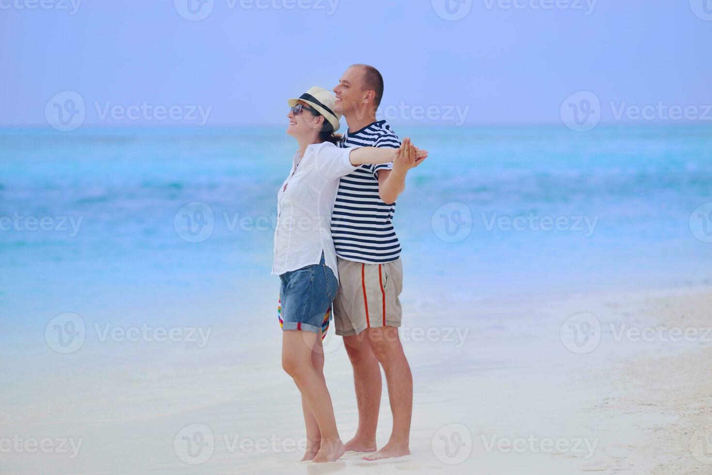 feliz pareja joven divertirse en la playa foto