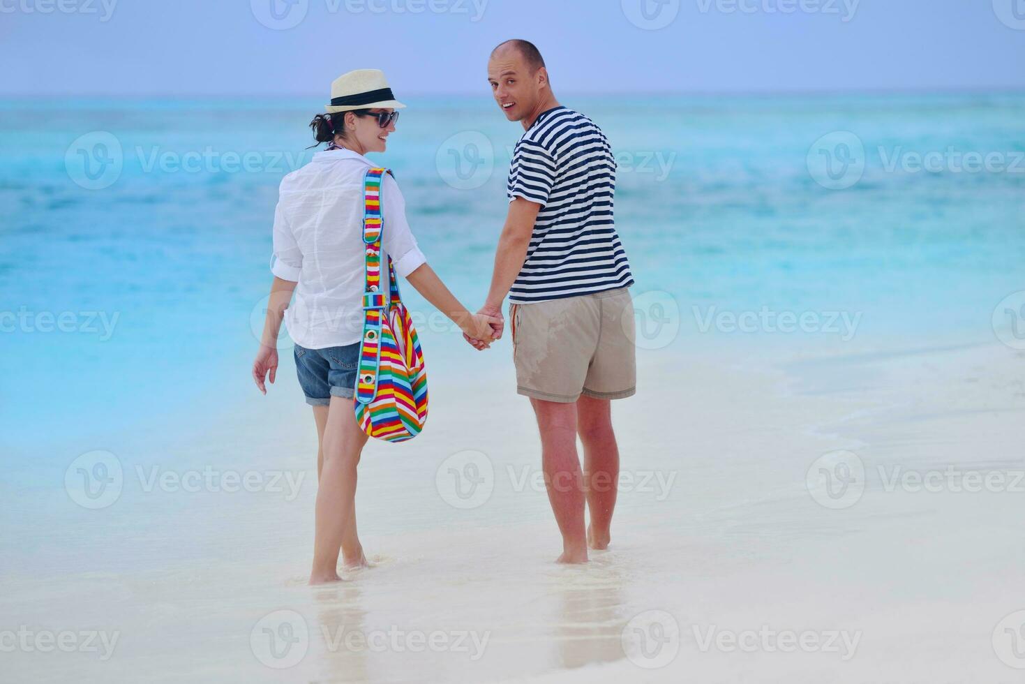 happy young couple have fun on beach photo