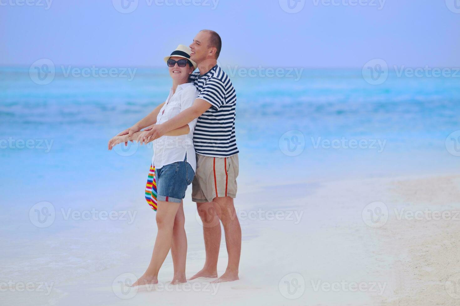 feliz pareja joven divertirse en la playa foto