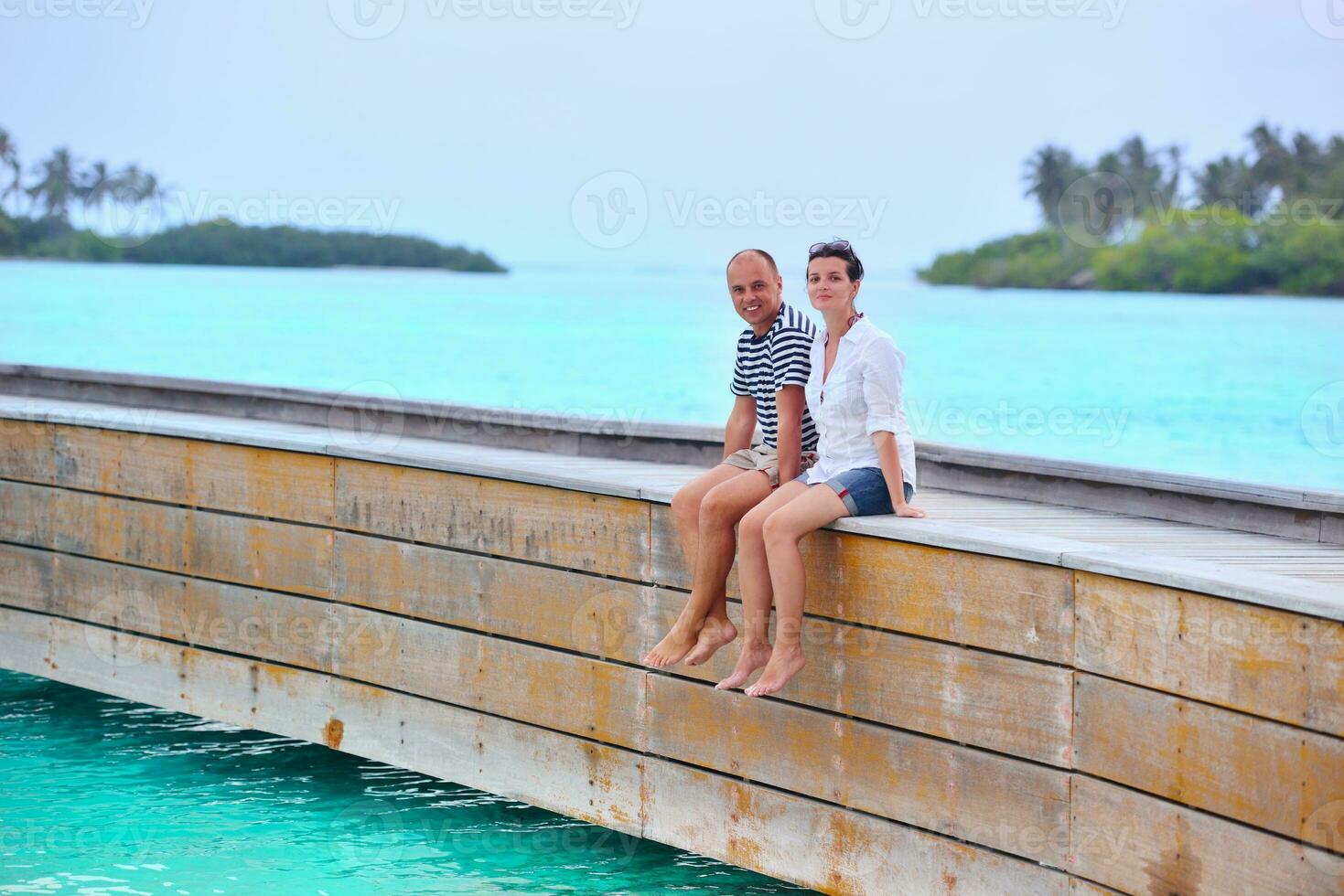 feliz pareja joven divertirse en la playa foto