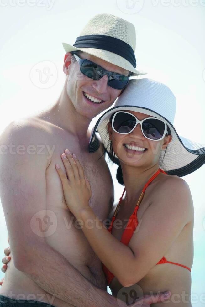 feliz pareja joven divertirse en la playa foto