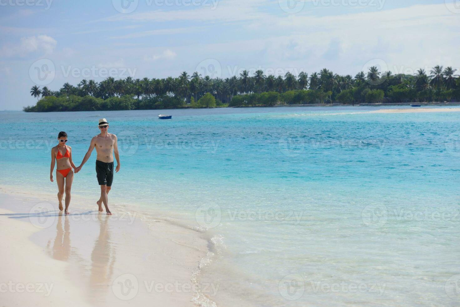 feliz pareja joven divertirse en la playa foto