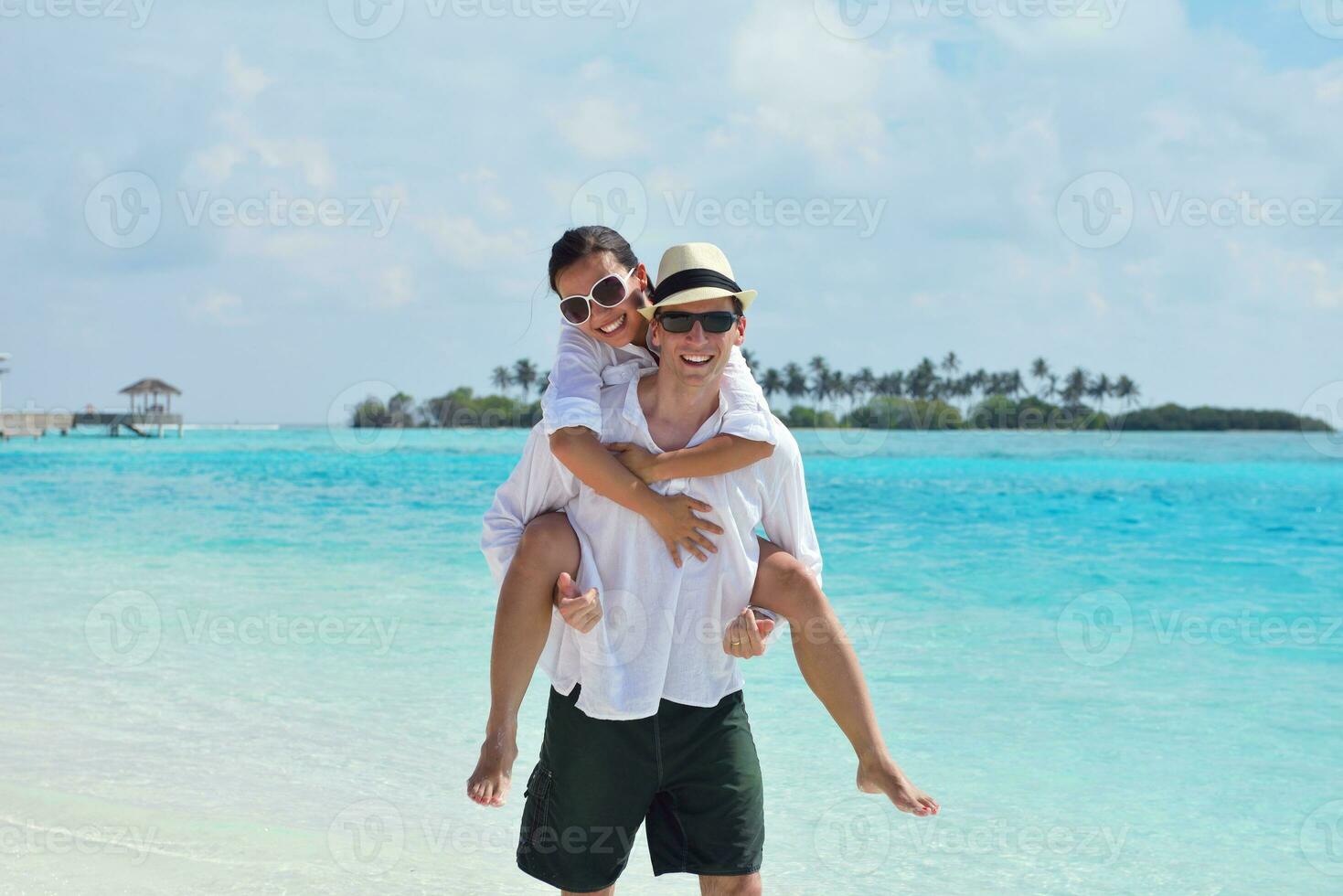 feliz pareja joven divertirse en la playa foto