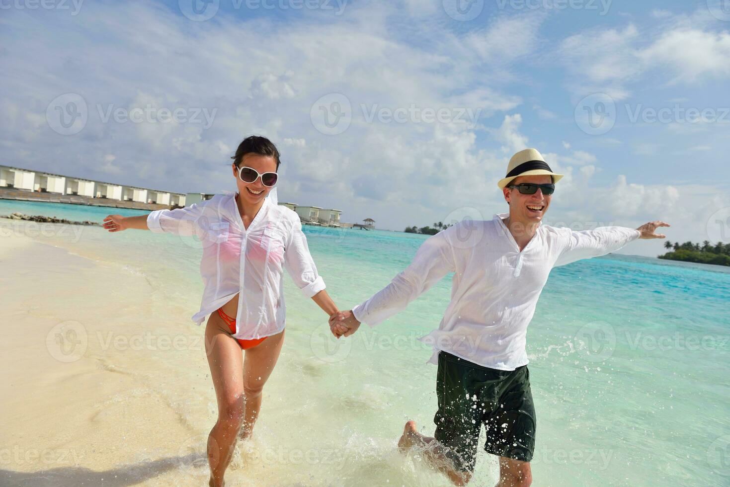 happy young couple have fun on beach photo