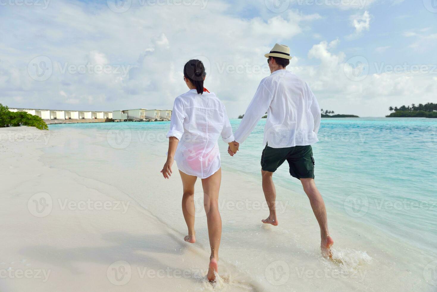 happy young couple have fun on beach photo