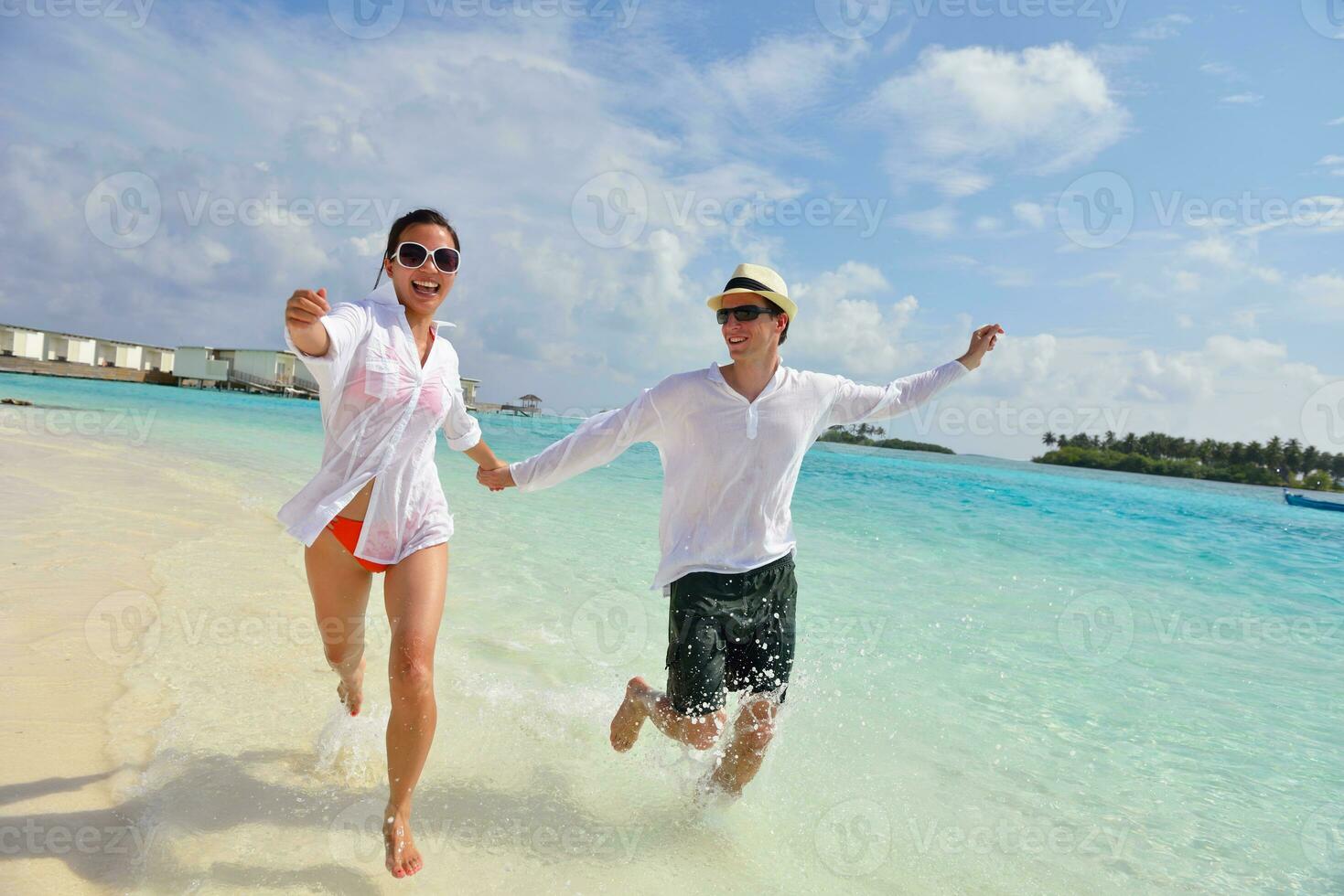 happy young couple have fun on beach photo