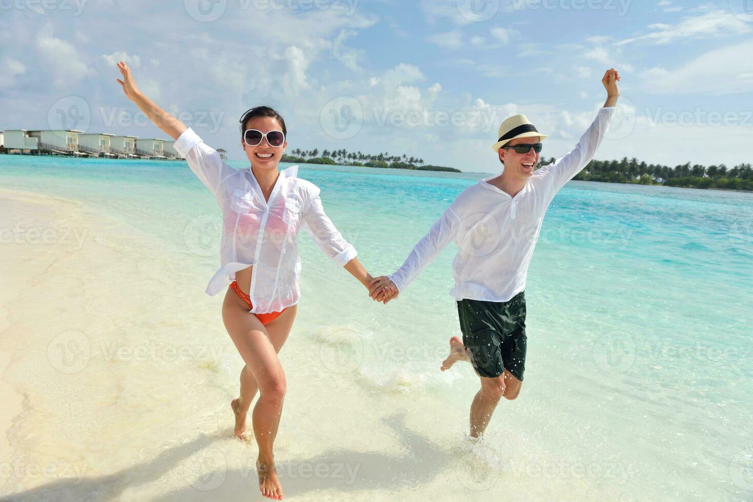 happy young couple have fun on beach photo