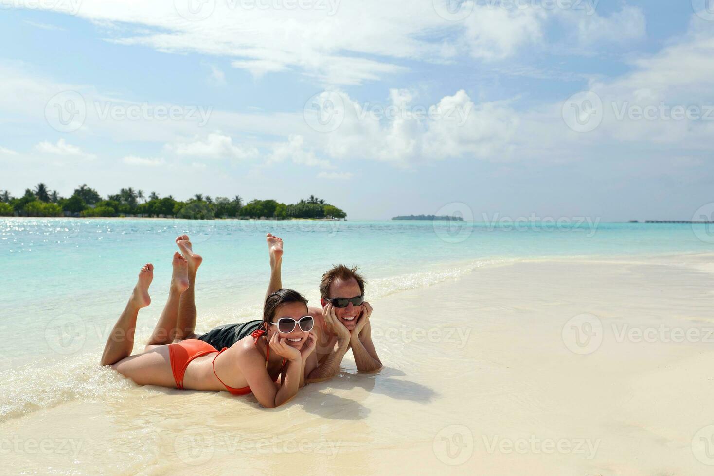 feliz pareja joven divertirse en la playa foto