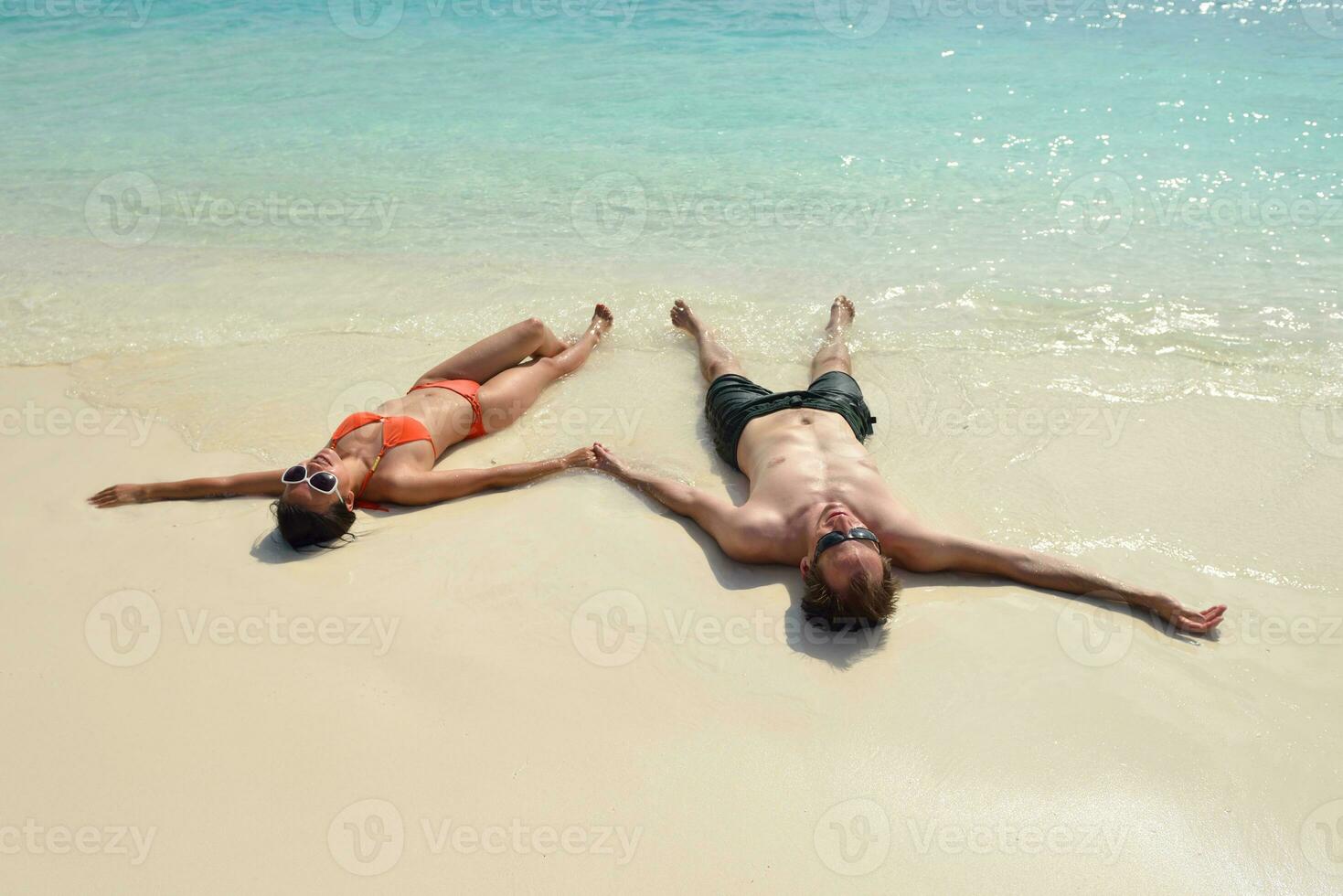 feliz pareja joven divertirse en la playa foto