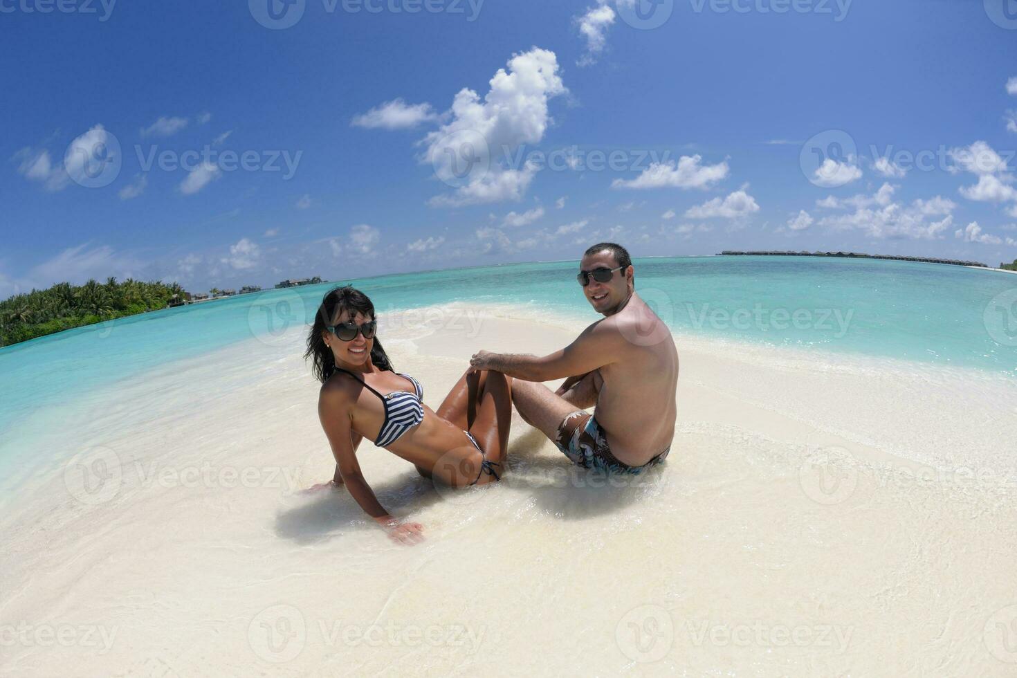 feliz pareja joven divertirse en la playa foto