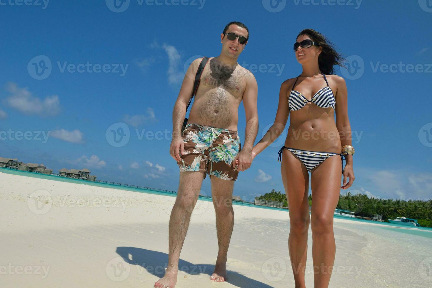 feliz pareja joven divertirse en la playa foto