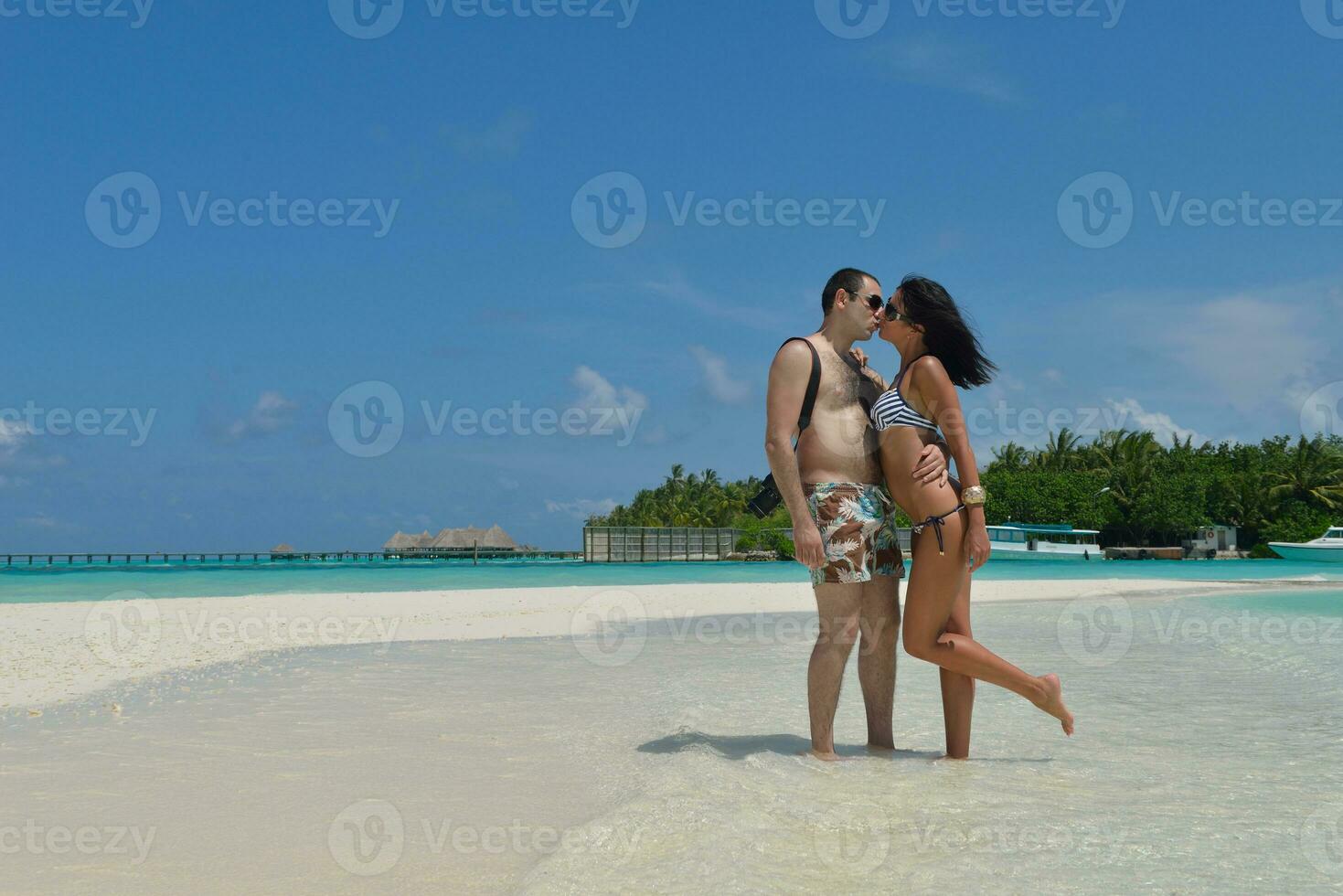 feliz pareja joven divertirse en la playa foto