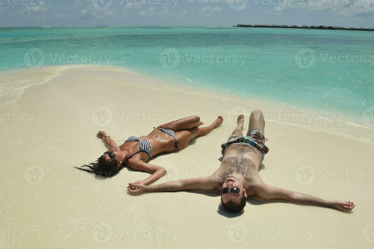 feliz pareja joven divertirse en la playa foto