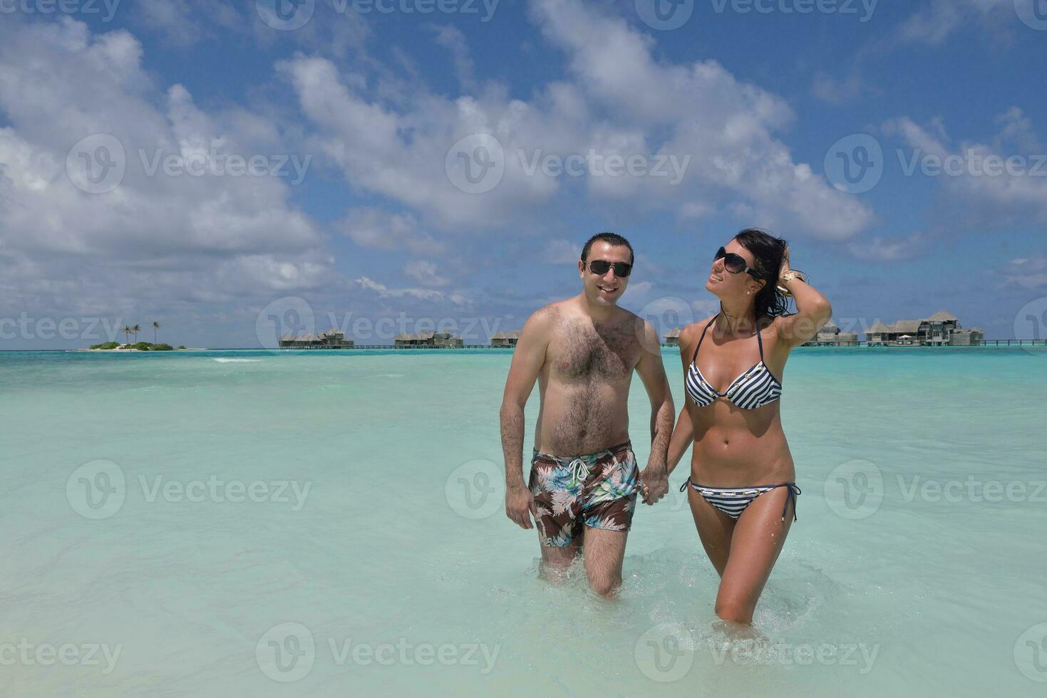 feliz pareja joven divertirse en la playa foto