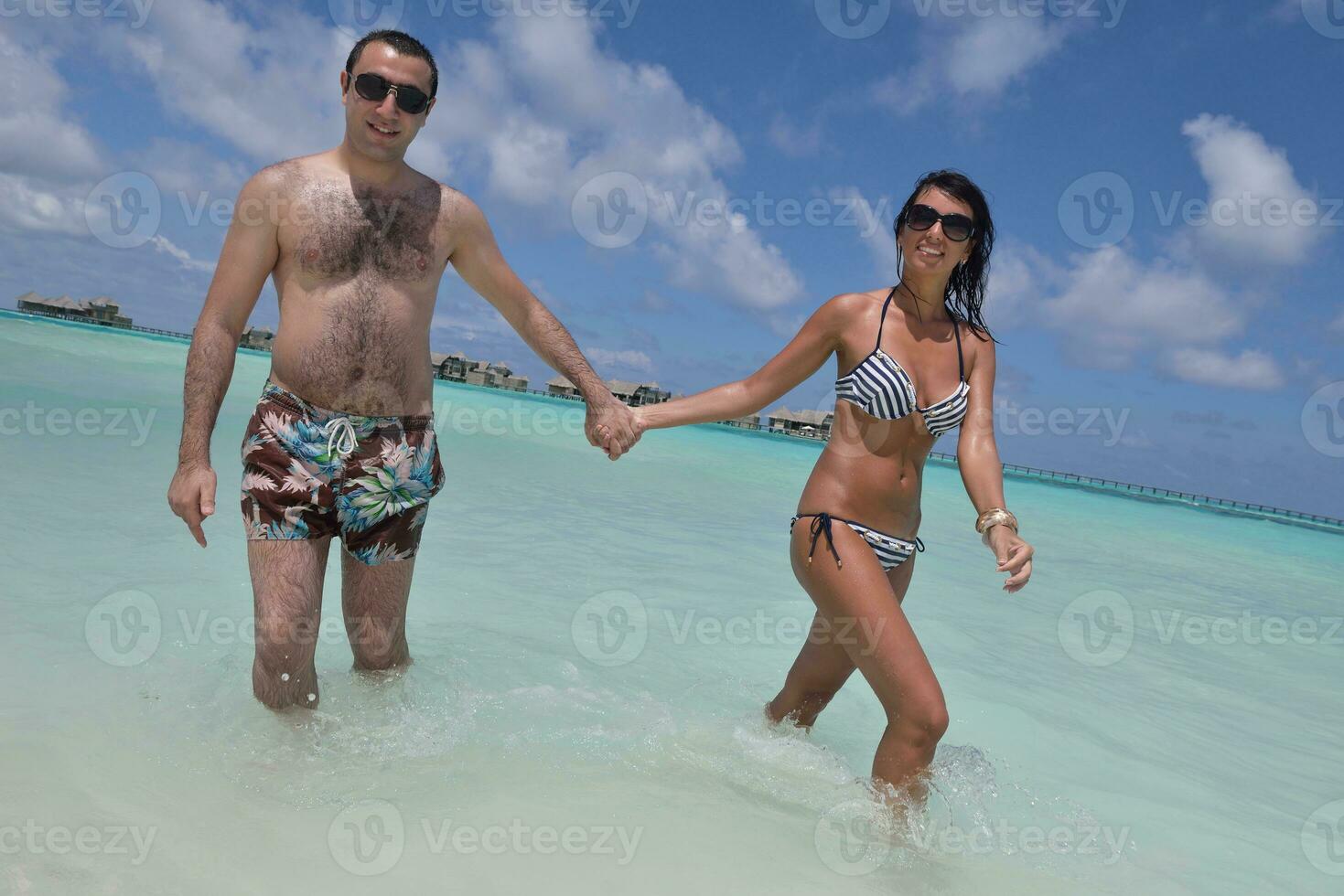 happy young couple have fun on beach photo