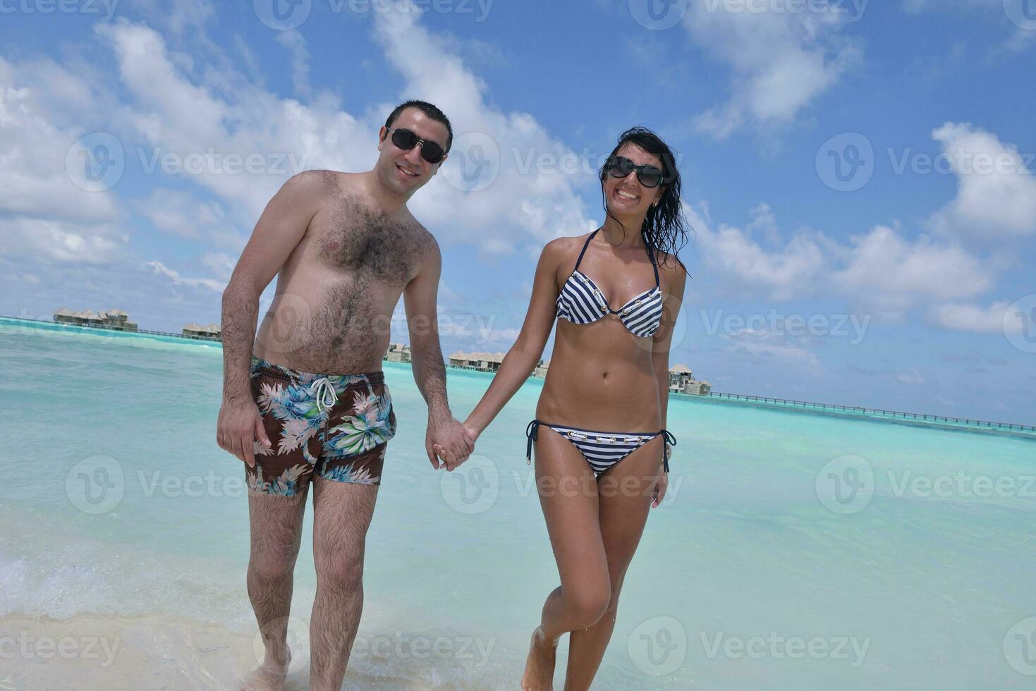 happy young couple have fun on beach photo