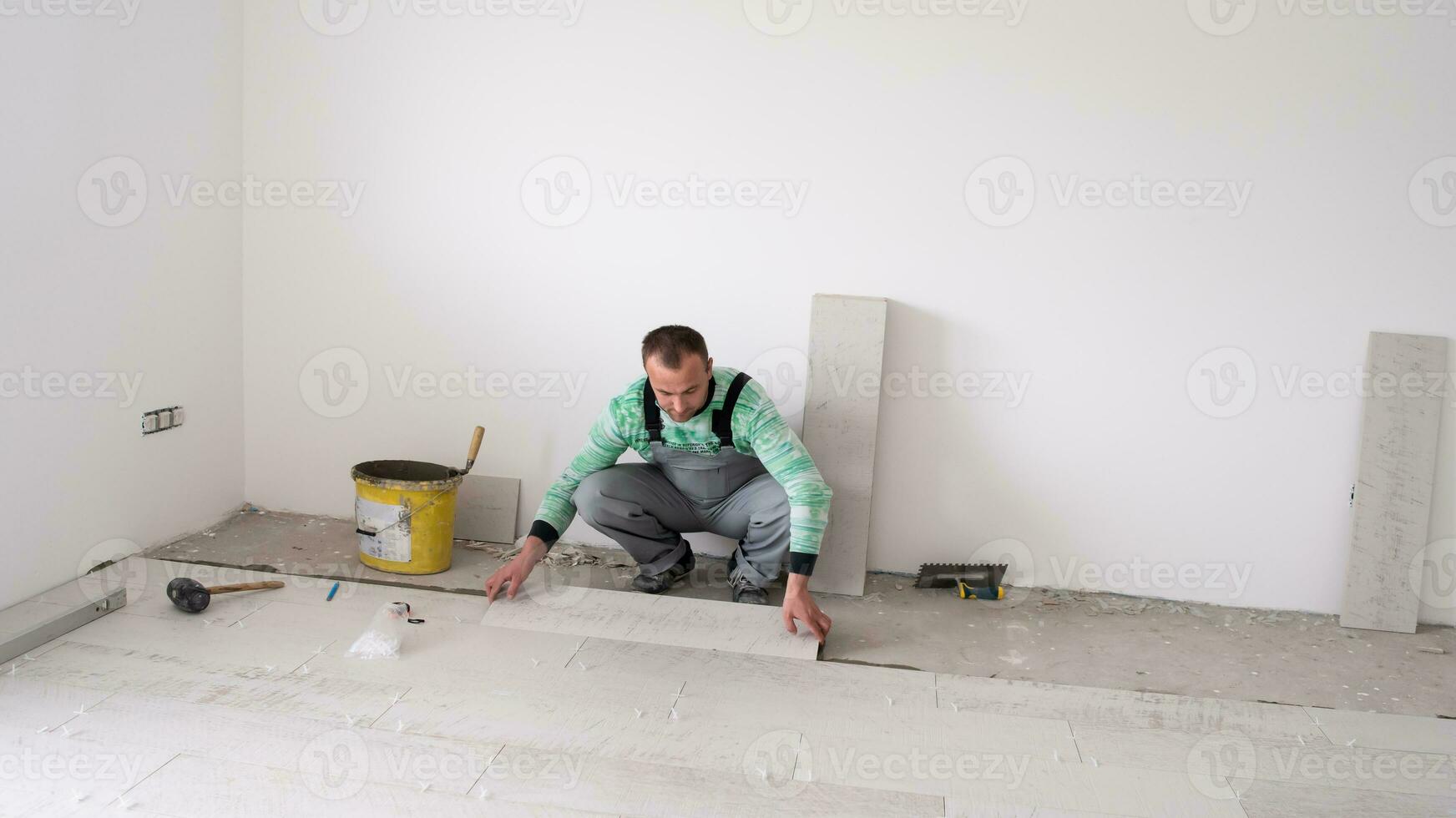 worker installing the ceramic wood effect tiles on the floor photo