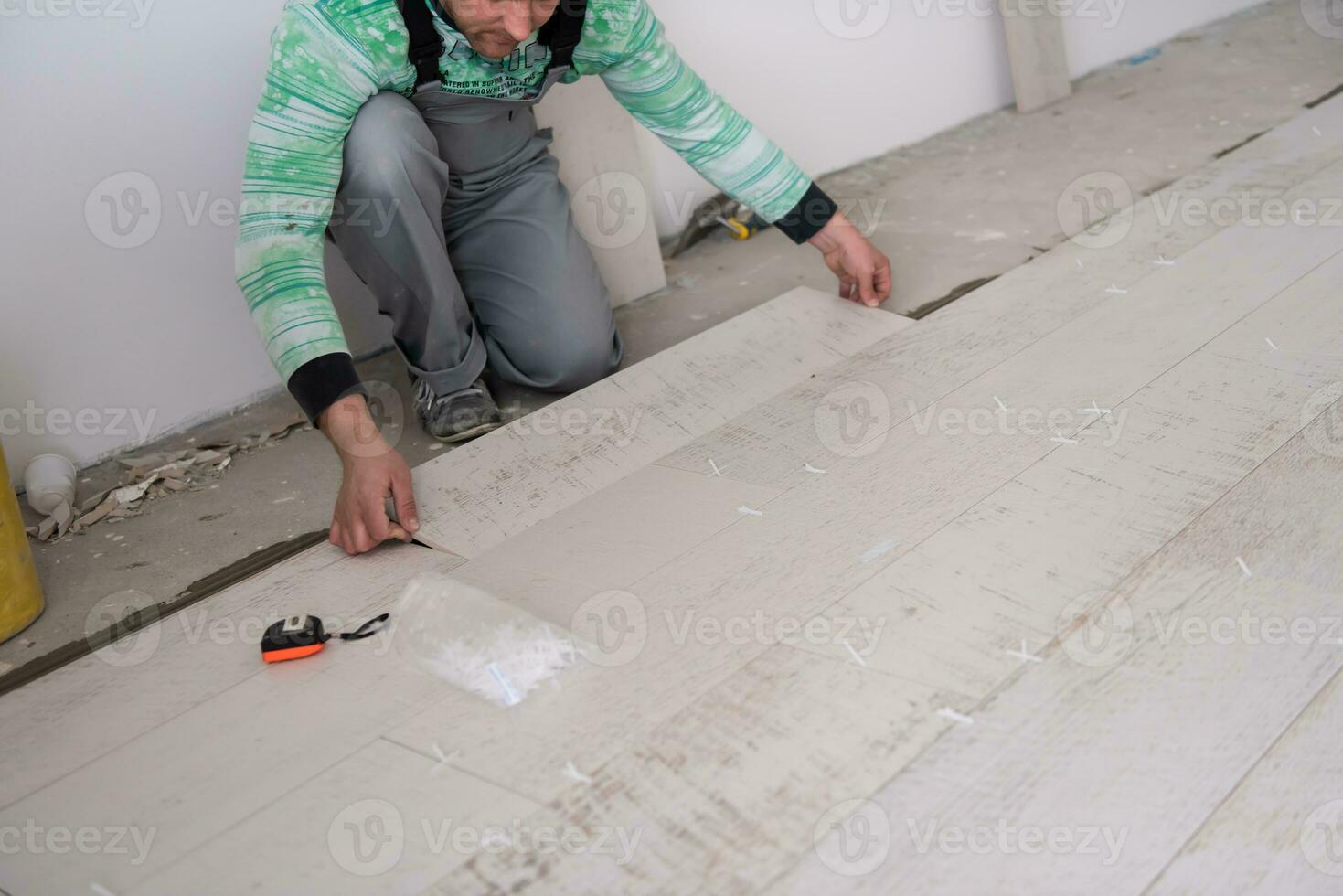 worker installing the ceramic wood effect tiles on the floor photo