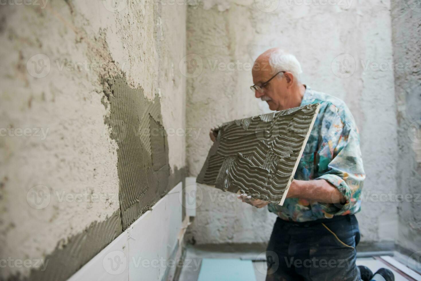 worker installing big ceramic tiles photo