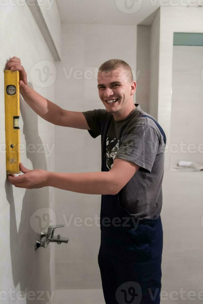 profesional fontanero utilizando burbuja nivel en un baño foto