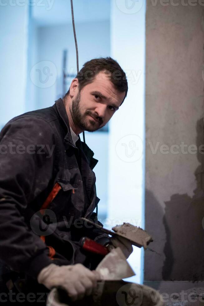 trabajador enyesando la pared con hormigón foto