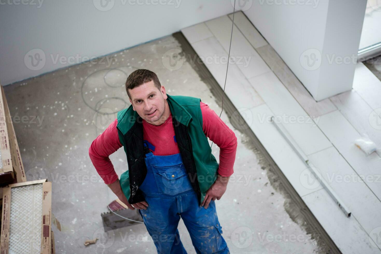 trabajador instalando las baldosas cerámicas con efecto madera en el suelo foto