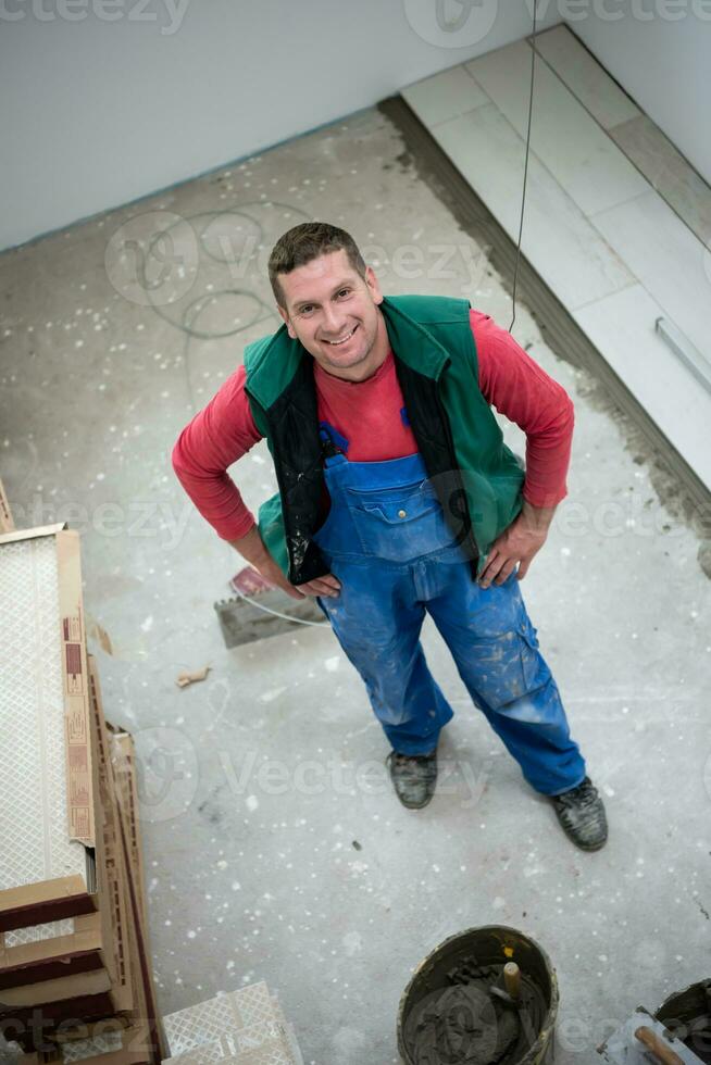 worker installing the ceramic wood effect tiles on the floor photo