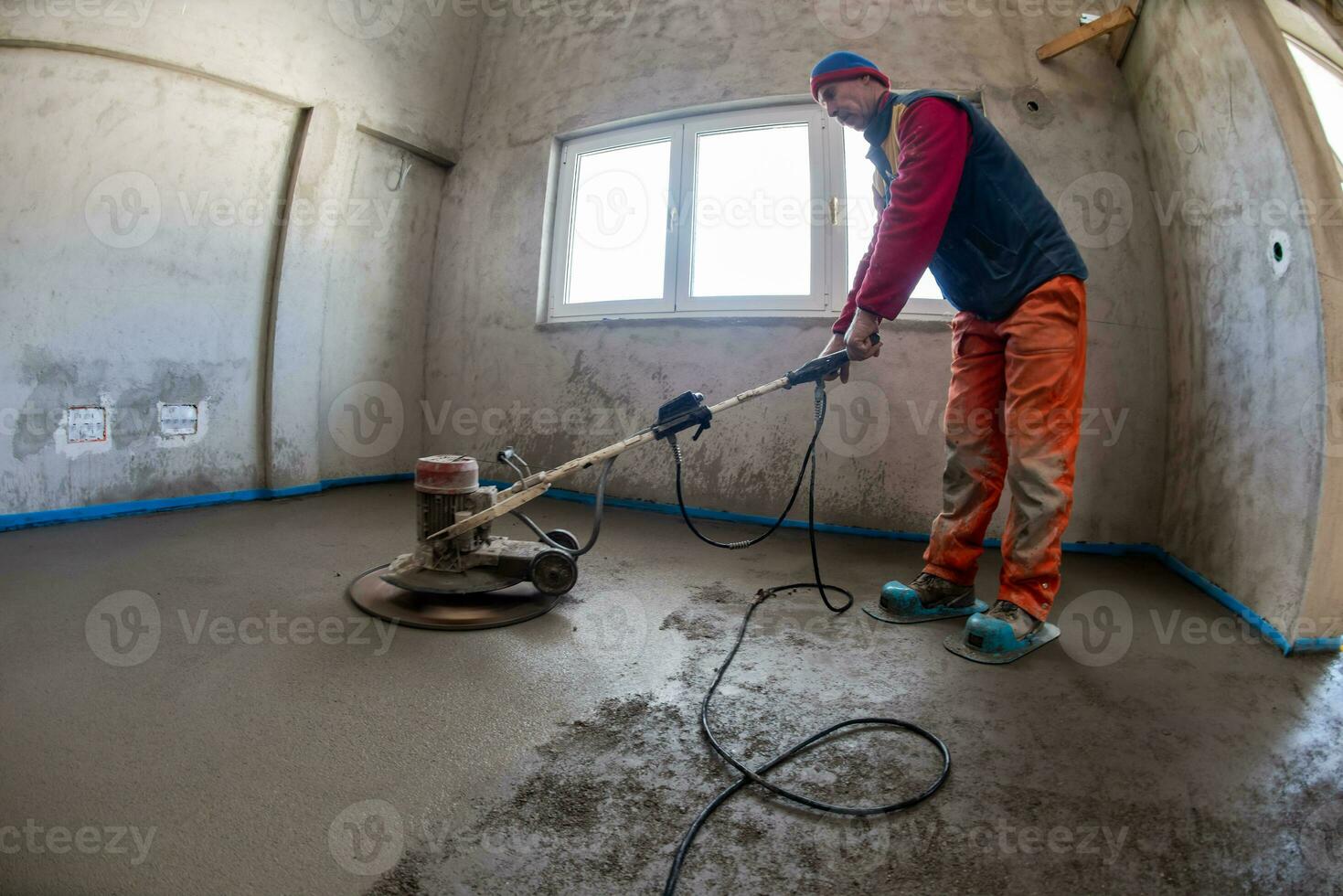 worker performing and polishing sand and cement screed floor photo