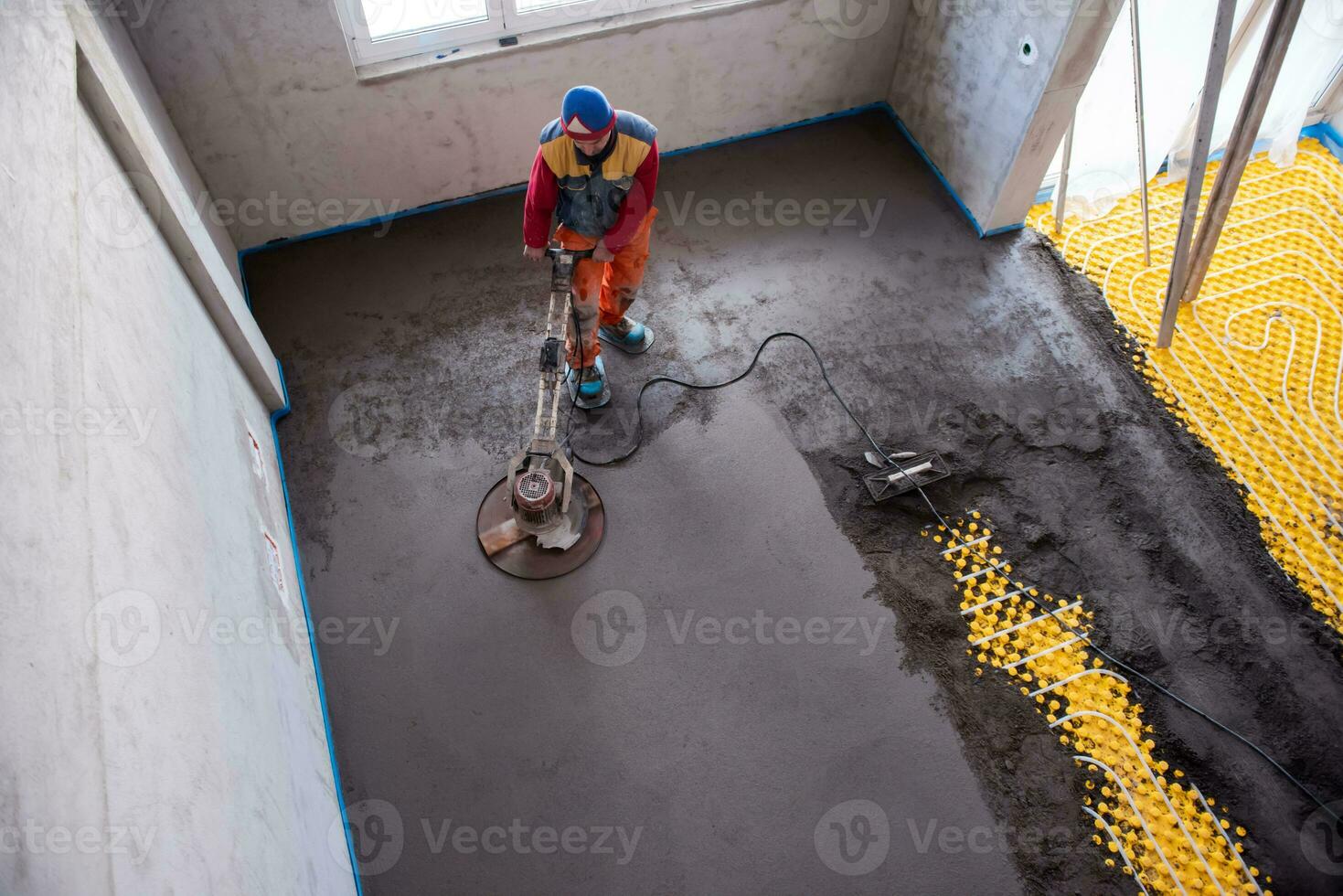 worker performing and polishing sand and cement screed floor photo