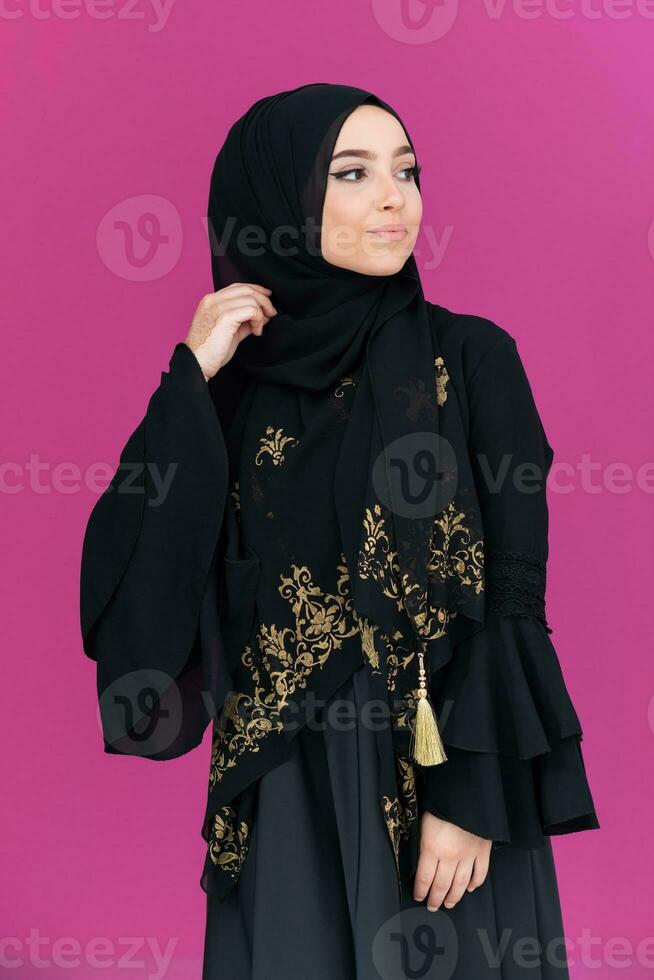 hermosa musulmán mujer en de moda vestir con hijab aislado en moderno rosado antecedentes representando concepto de moderno islam y Ramadán kareem foto