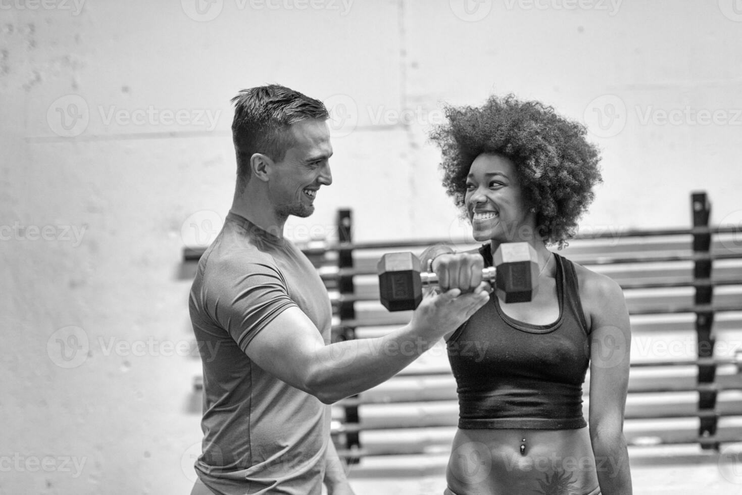 black woman doing bicep curls with fitness trainer photo