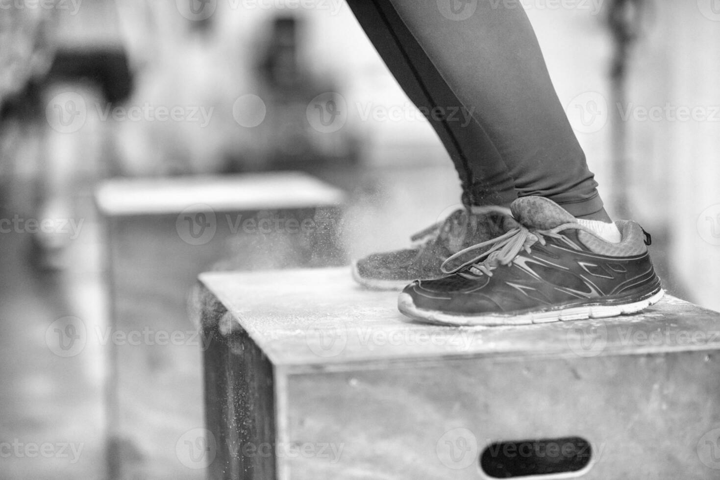 black woman is performing box jumps at gym photo