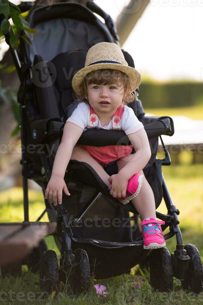baby girl sitting in the baby stroller photo