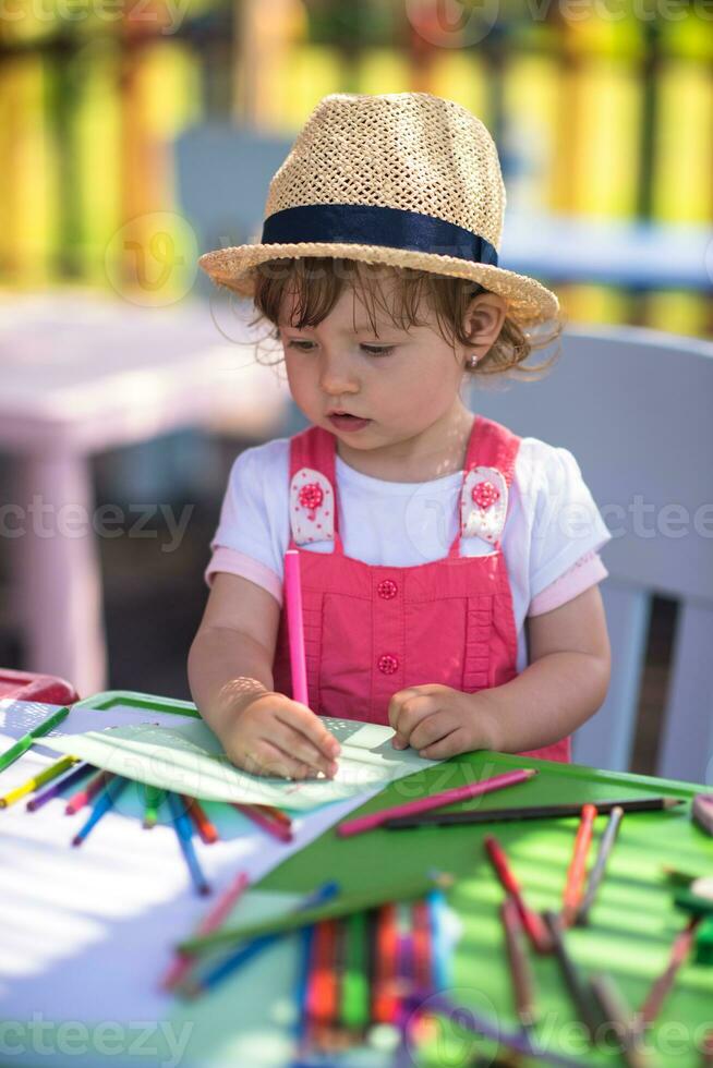 niña dibujando imágenes coloridas foto