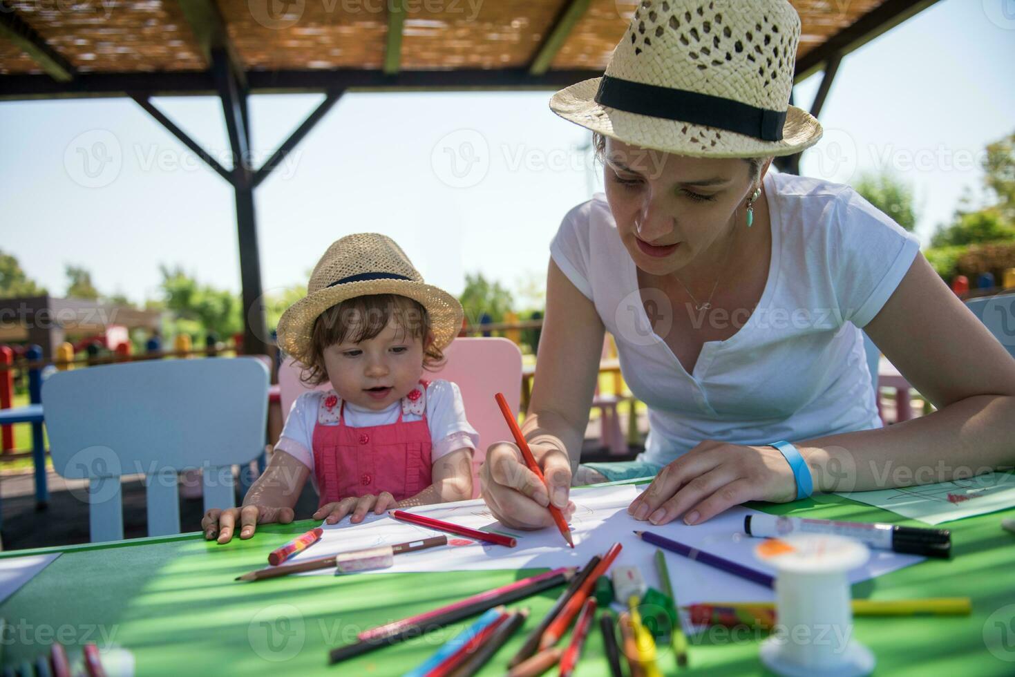 mamá y su pequeña hija dibujando imágenes coloridas foto