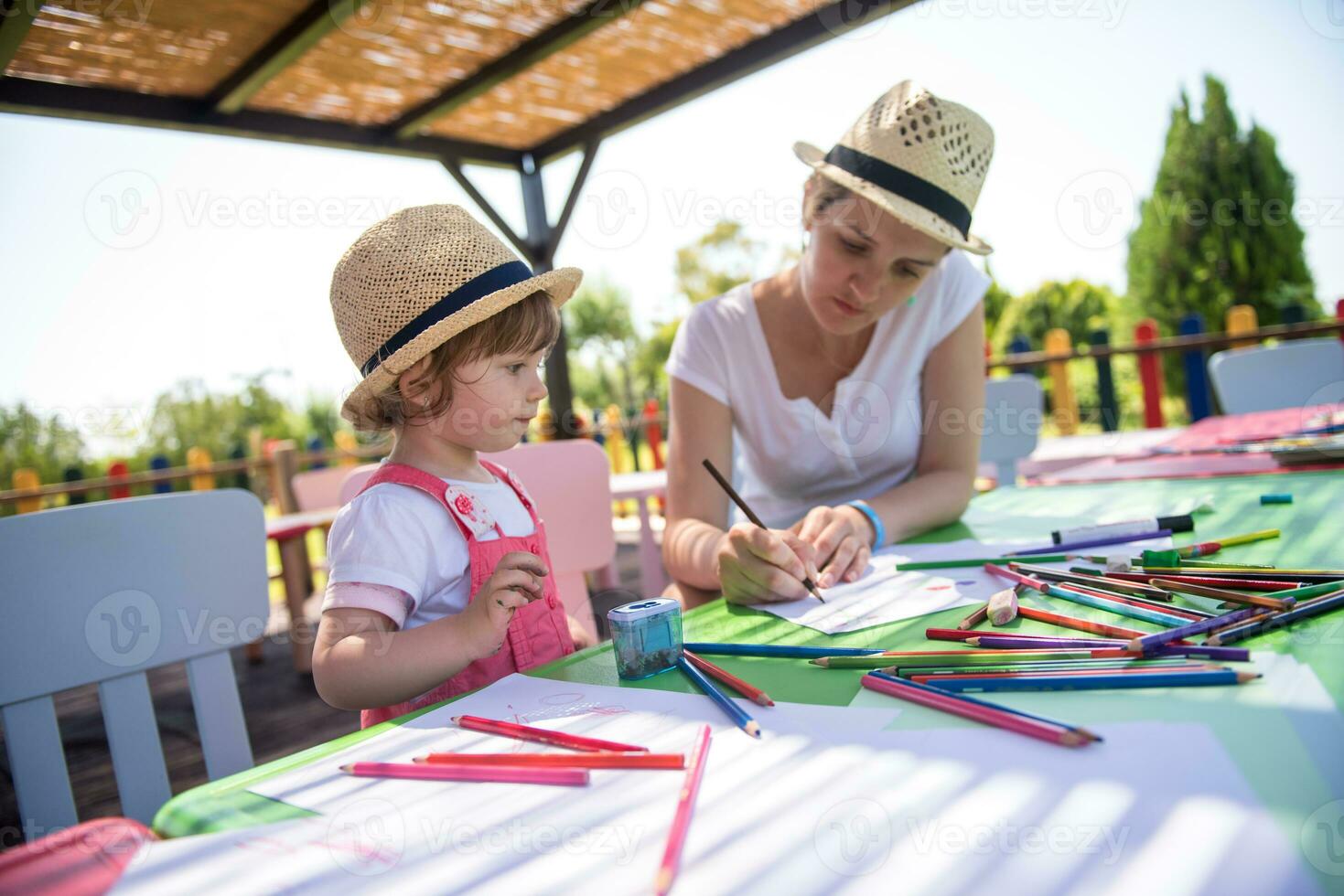 mom and little daughter drawing a colorful pictures photo