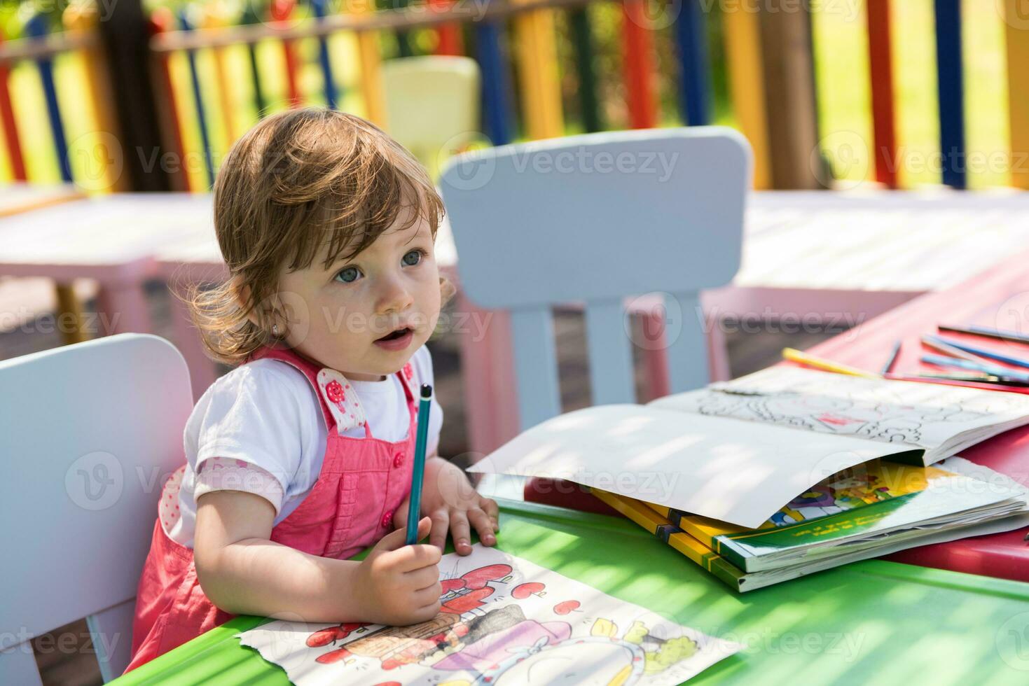 little girl drawing a colorful pictures photo