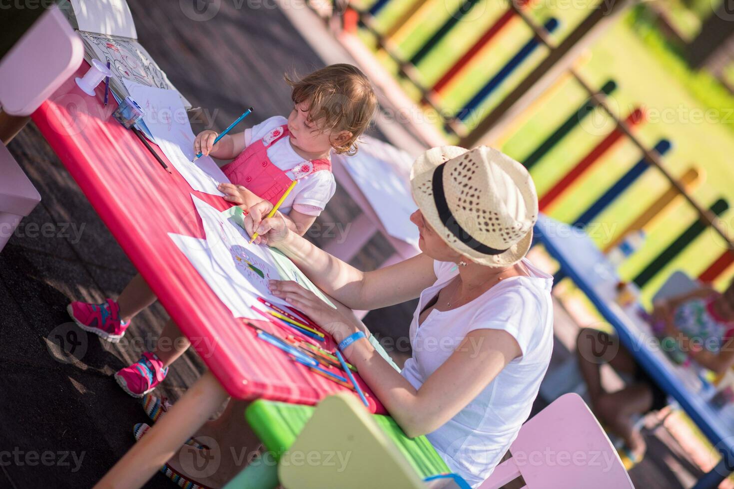 mamá y su pequeña hija dibujando imágenes coloridas foto