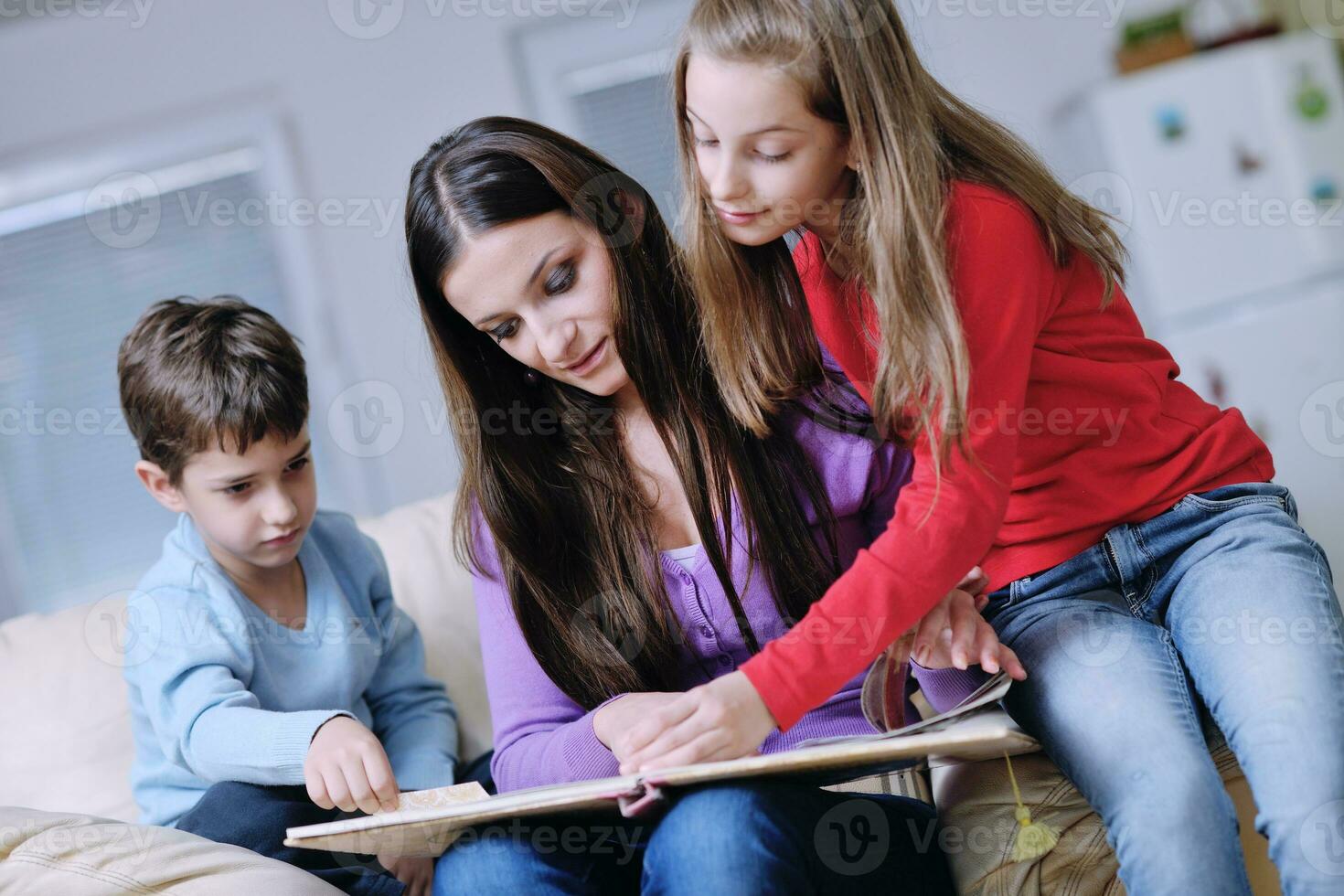 young mom play with their kids at home and reading book photo