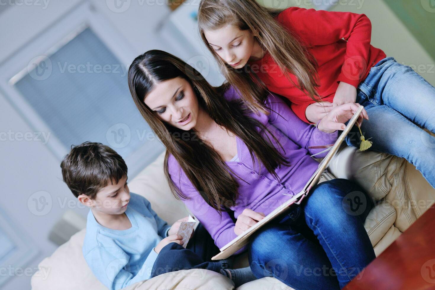 young mom play with their kids at home and reading book photo