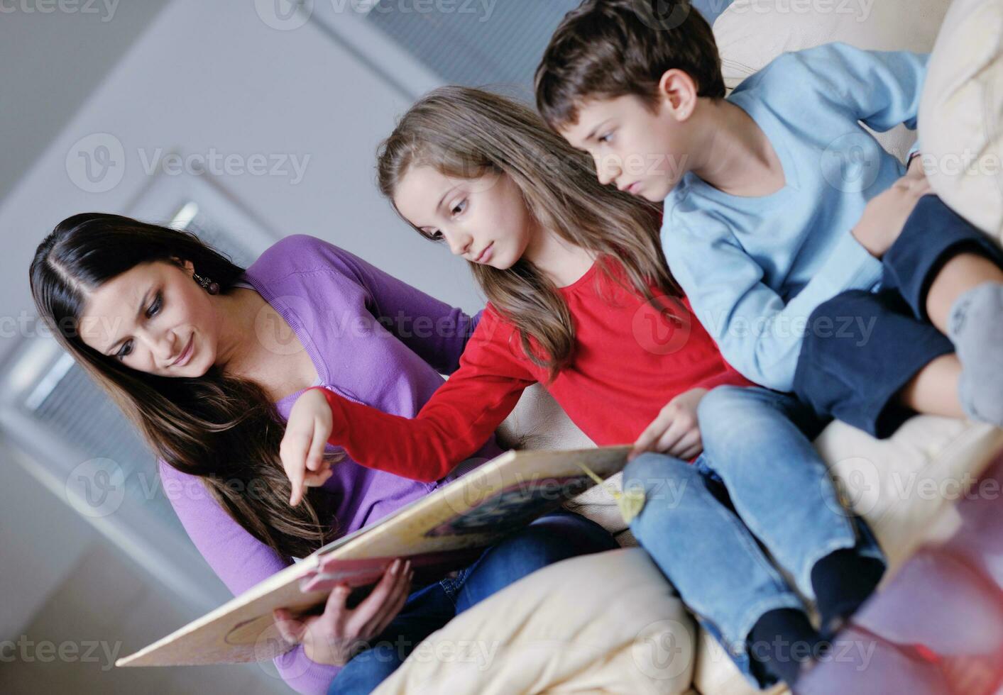 young mom play with their kids at home and reading book photo